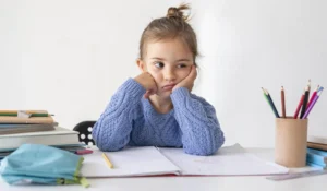 Criança desanimada estudando desafiando o tdah