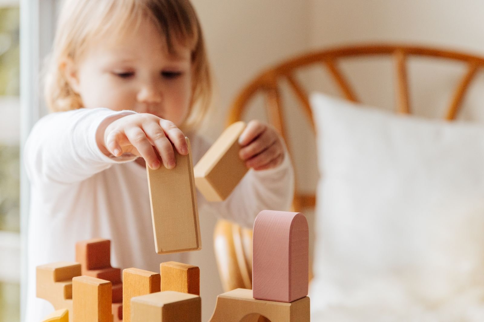 Menina brincando com blocos de madeira em casa