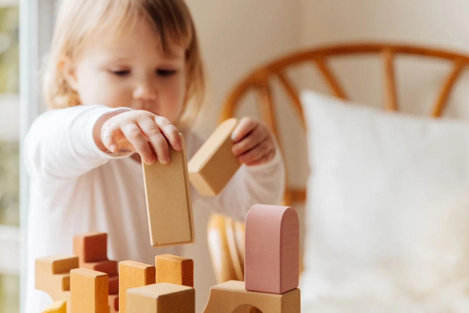 Menina brincando com blocos de madeira em casa
